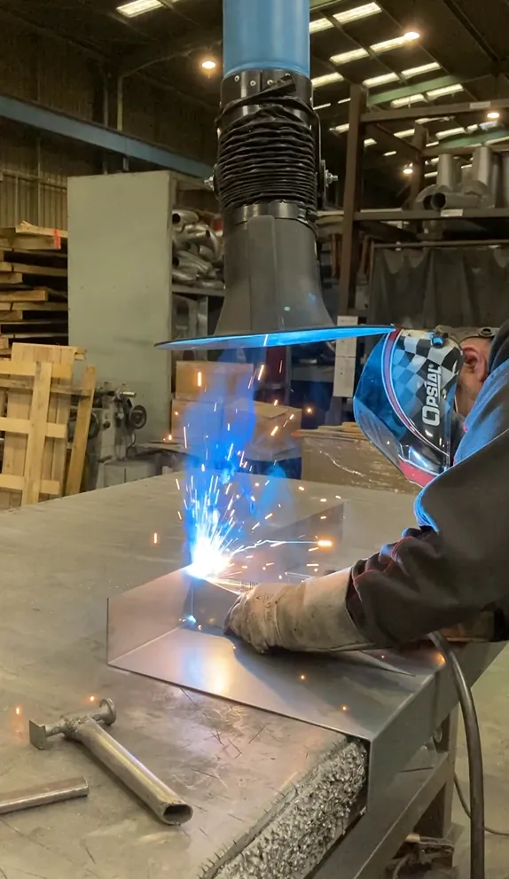 Welding extraction hood in use at a fabrication bench
